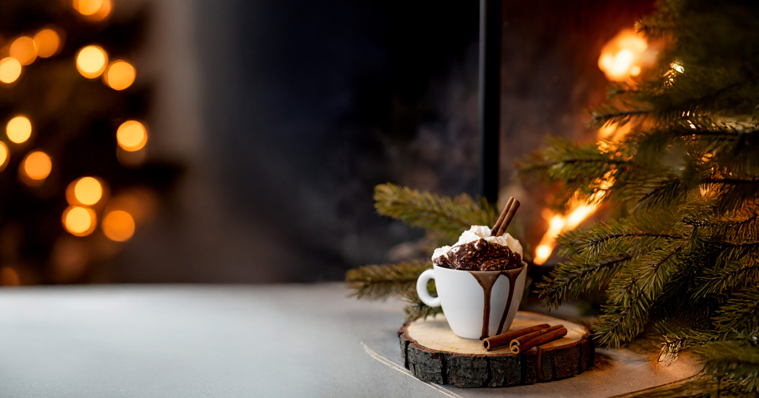 hot chocolate in an outdoor festively lit setting for the holidays